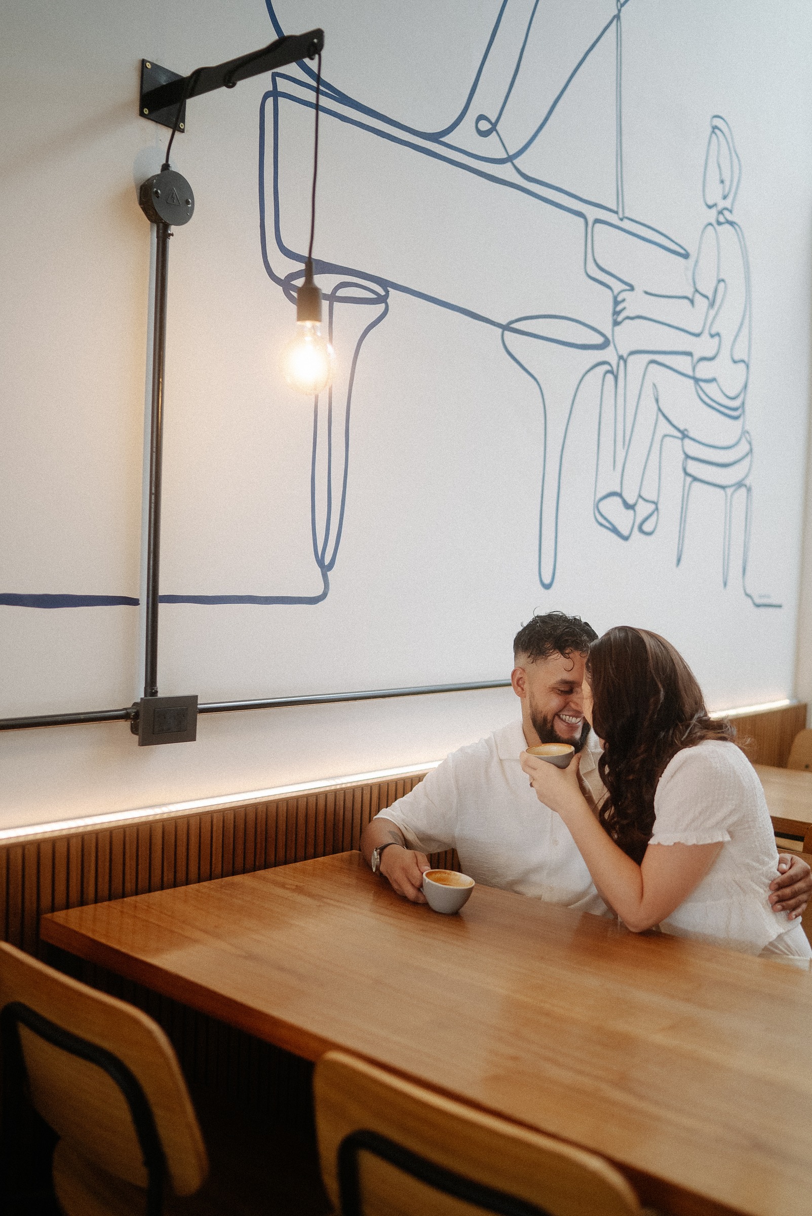 Pareja en sesión pre-boda dentro de un café con murales modernos en Buenos Aires - locaciones interiores con carácter - Lucas Todaro